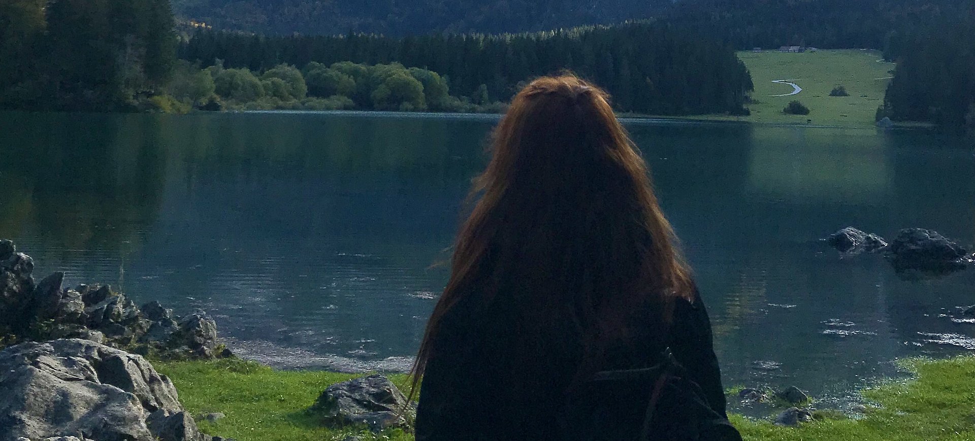 Mädchen sieht auf See und Berge bei ihrem FSJ in Östereich