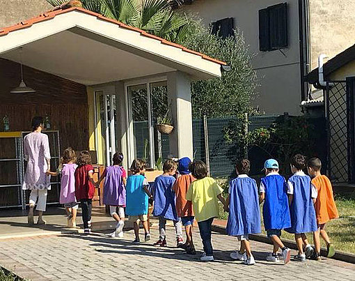 Kinder laufen in ein Gebäude beim FSJ in Italien