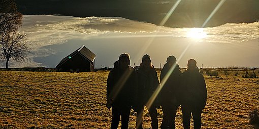 FReiwillige sehen sich den Sonnenuntergang über einem See beim FSJ in Norwegen anntergang