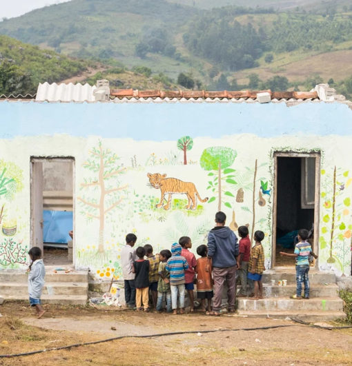Kinder bemalen eine Wand beim FSJ Indien.