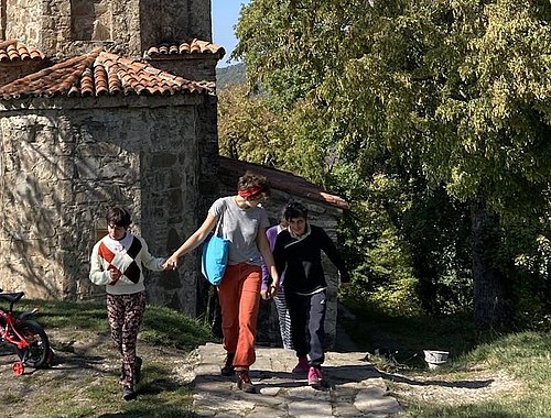 Freiwillige Hand in Hand mit Kindern vor einem Turm beim FSJ in Russland
