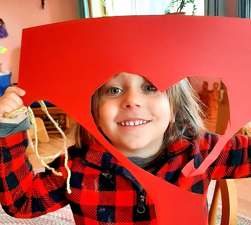 Kleiner Junge mit rotem Blatt in Herzform beim FSJ an der Camphillschool Beaverrun.