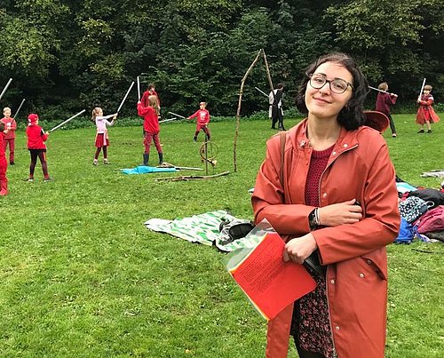 Mädchenauf Wiese, im Hintergrund spielen Kinder beim FSJ in den Niederlanden