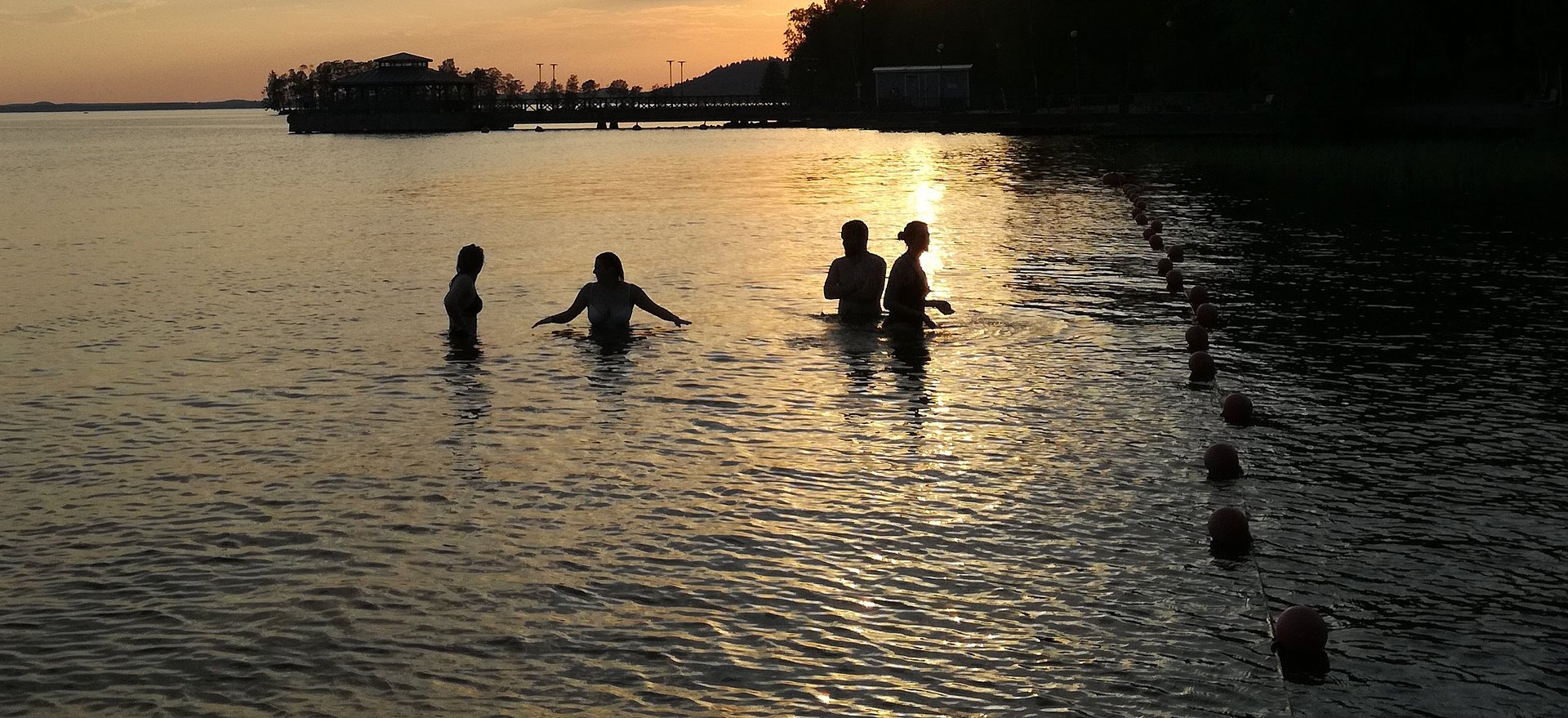 Im See schwimmen bei Sonnenuntergang im FSj Finnland
