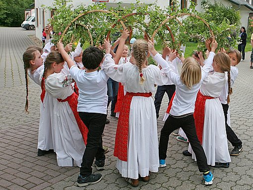 Kinder tragen Efeukränze an einer Schule beim FSJ in Essen