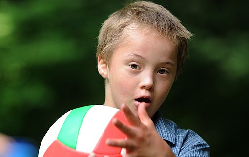 Junge spielt mit Ball beim FSJ Heilpädagogik.