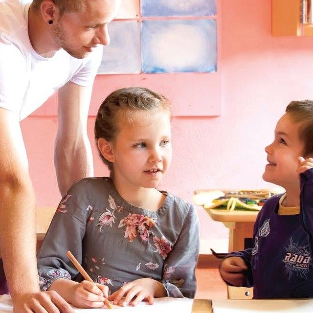 Freiwilliger hilft Schüler*innen beim FSJ Schule