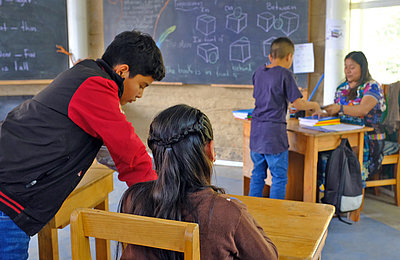 Kinder und ihre Lehrerin in einem Klassenzimmer in Guatemala.