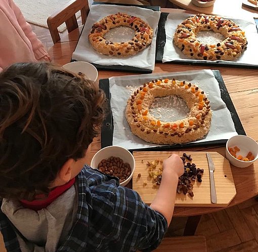 Kind schmückt Teigkränze mit Früchten und Rosinen beim FSJ in Portugal