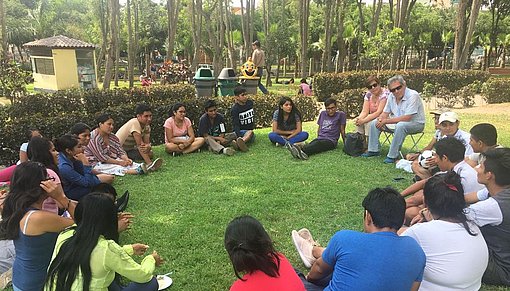 Menschengruppe sitzt auf der Wiese beim FSJ in Peru