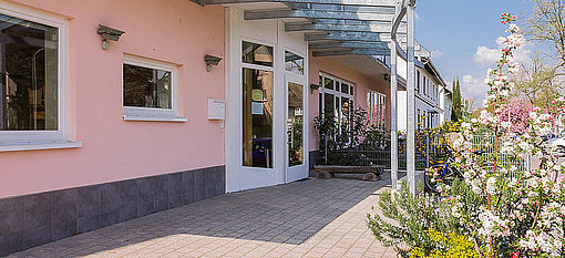 Schönes Gebäude mit rosaner Fassade und Blumen beim FSJ