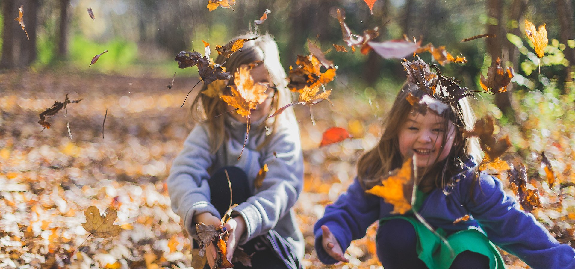 Kinder spieln im Herbst mit Blättern im FSJ Kindergarten