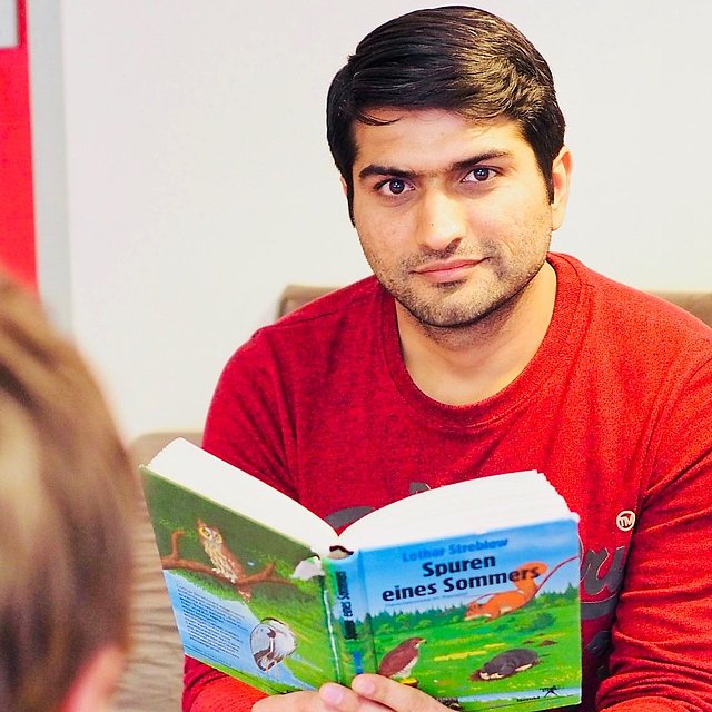 Incoming Freiwilliger liest aus einem Buch vor beim FSJ Schule