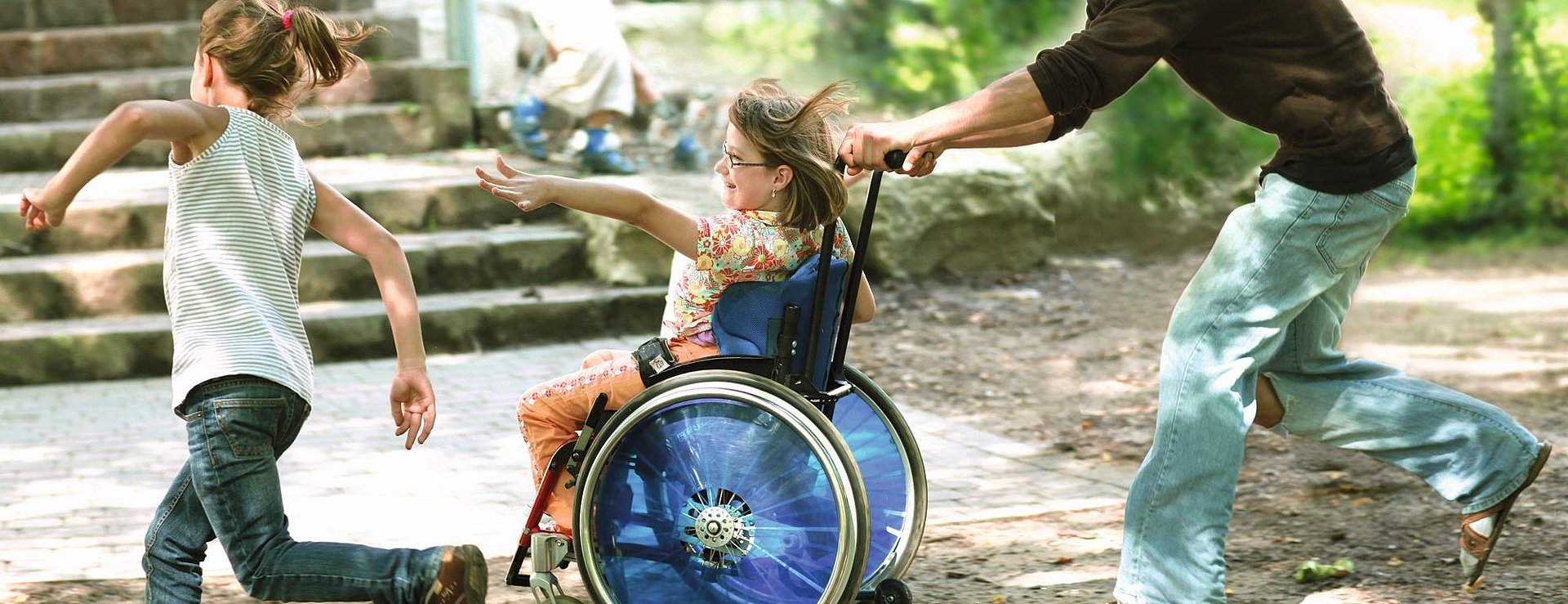 Freiwilliger spielt mit Kind im Rollstuhl beim FSJ Heilpädagogik.