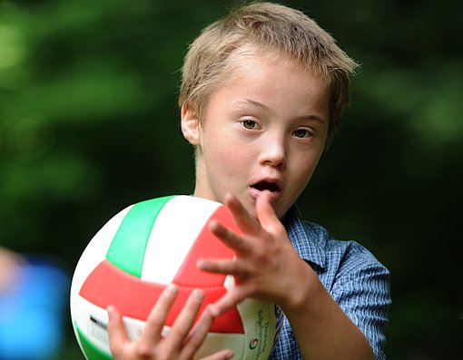 Junge spielt mit Ball beim FSJ Heilpädagogik.