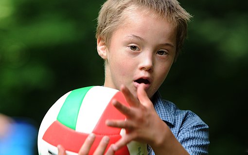 Junge spielt mit Ball beim FSJ Heilpädagogik.