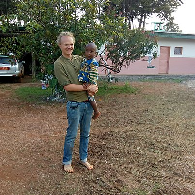 Mann mit Kind auf dem Arm beim FSJ in Südafrika