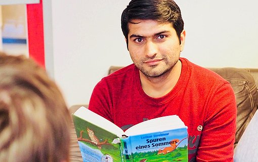 Incoming Freiwilliger liest aus einem Buch vor beim FSJ Schule