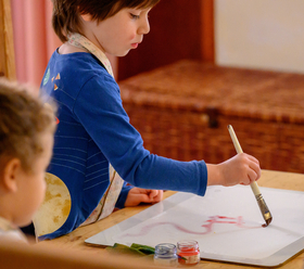 Ein Bustan Waldorfkindergarten Israel Junge malt mit Pinsel