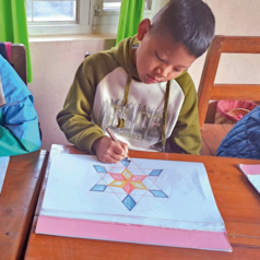 Tashi Waldorf School Nepal Junge malst Stern in Wladorfschule Nepal