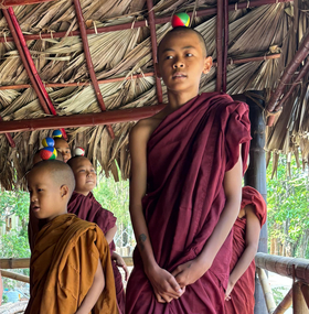 Notfallpädagogik Myanmar Kinder in roter Mönchskleidung balancieren kleine bunte Bälle auf dem Kopf