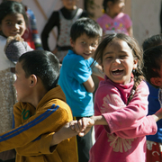 Kinder halten sich an der Hand und lachen
