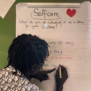 Selbstfürsorge Notfallpädagogik Person schreibt auf Whiteboard zum Thema Selbstfürsorge